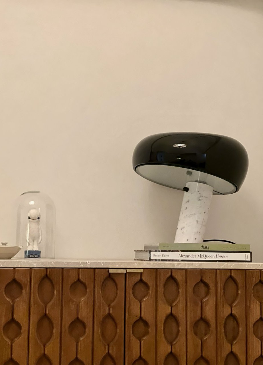 Black and marble table lamp on a carved wooden sideboard